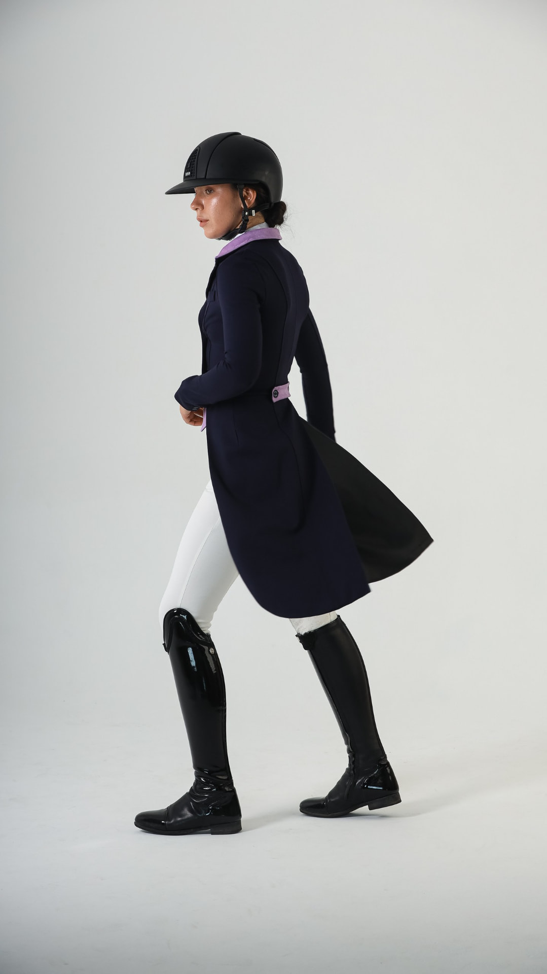 Rider in a navy bespoke dressage tailcoat with lilac collar and patent boots