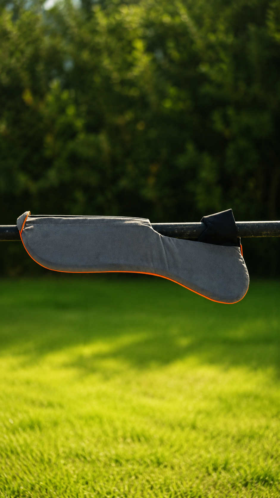 Grey suede shock absorber pad with orange piping on a rail