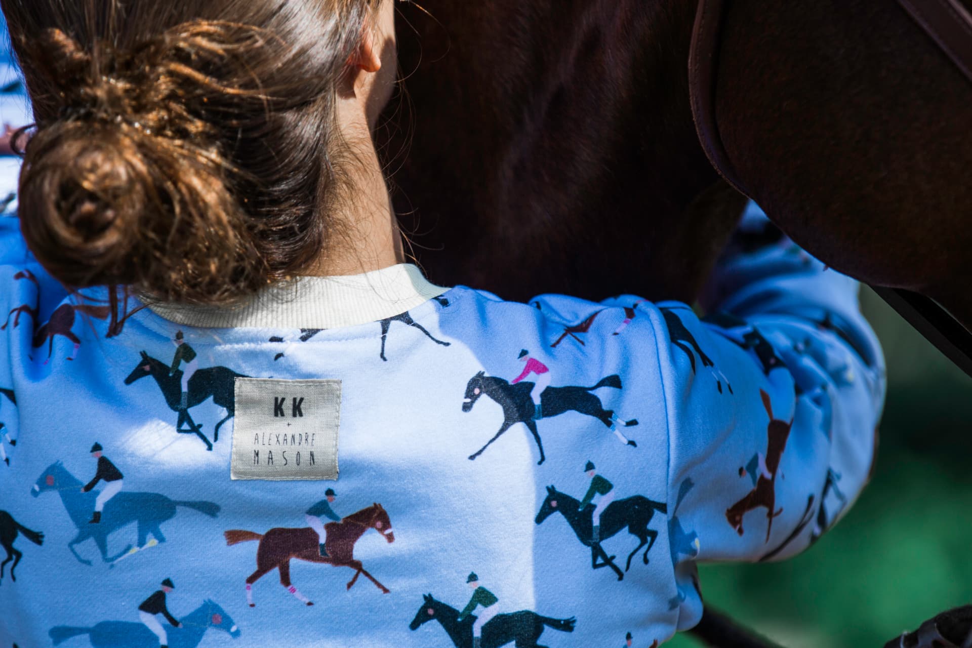 Back of a light blue printed sweatshirt with the KK and Alexandre Mason label