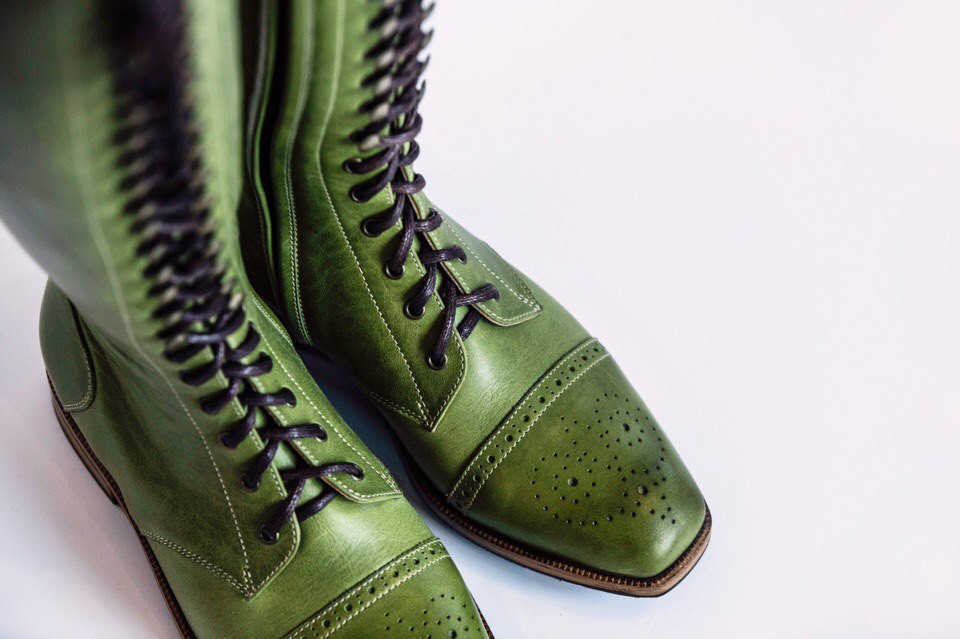 Pair of olive green laced boots with brogue toe caps