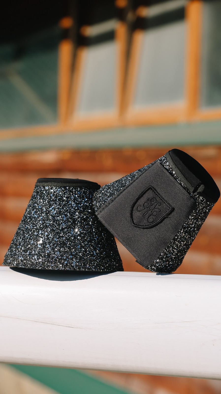 Pair of black glitter bell boots with embroidered crest