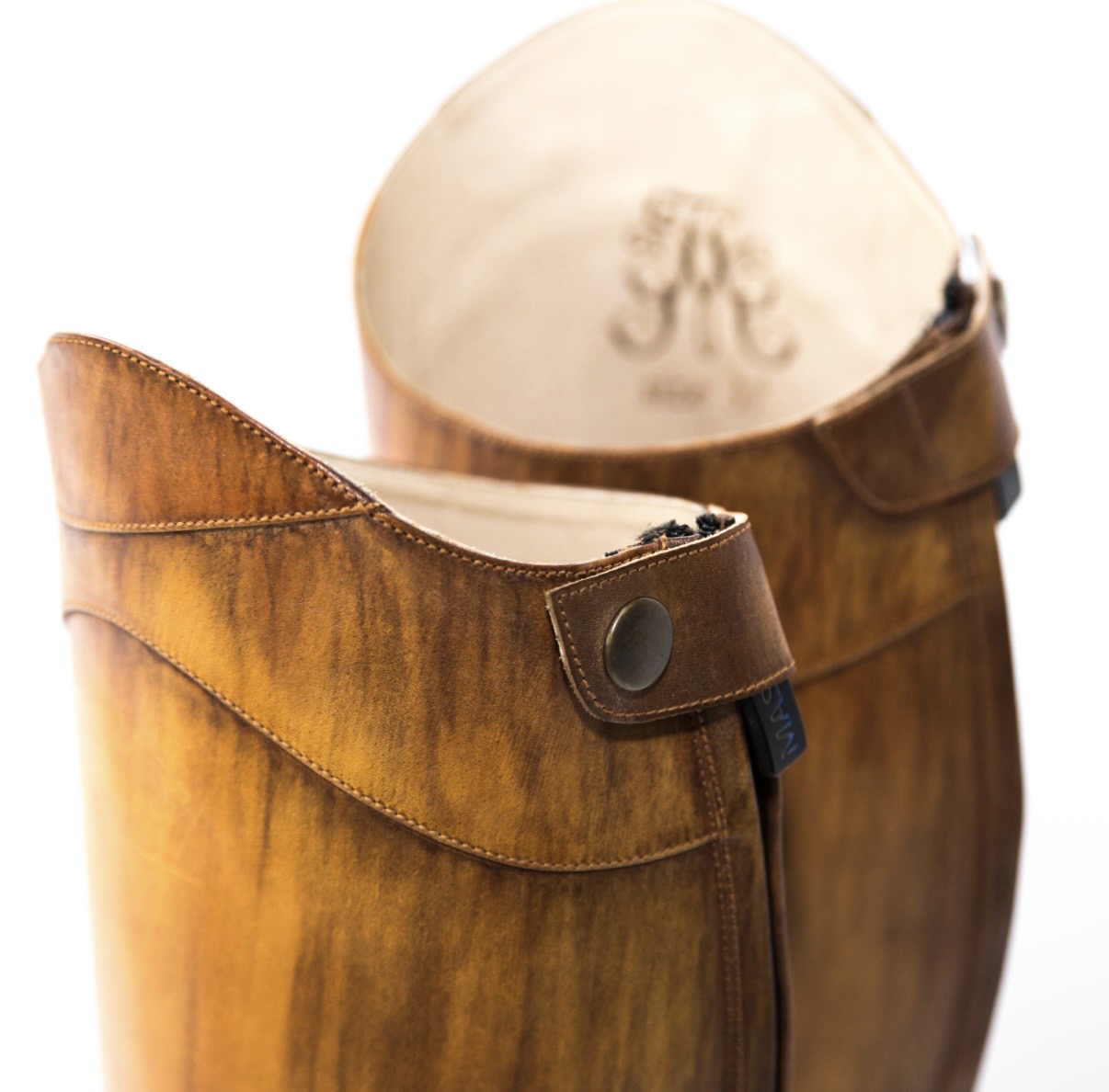 Detail of hand-patinated cognac leather riding boots with monogrammed lining