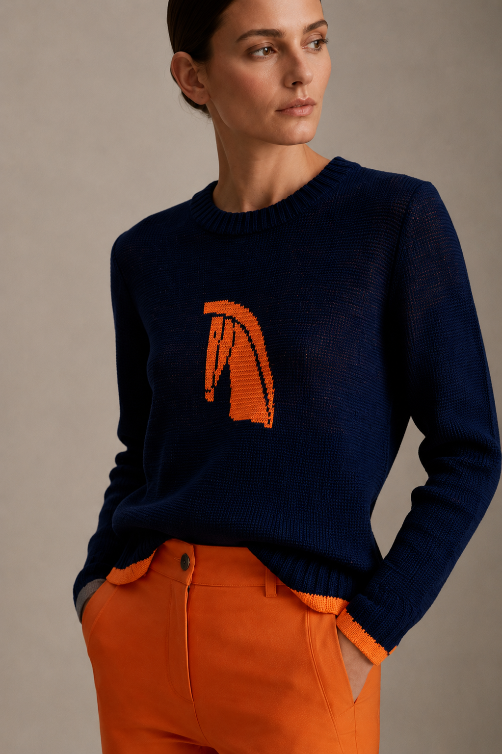 Close view of a navy hand-knitted sweater with an orange horse motif