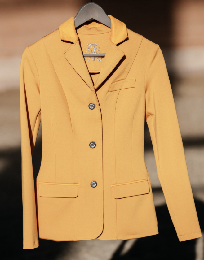 Monogrammed ochre competition jacket on a hanger