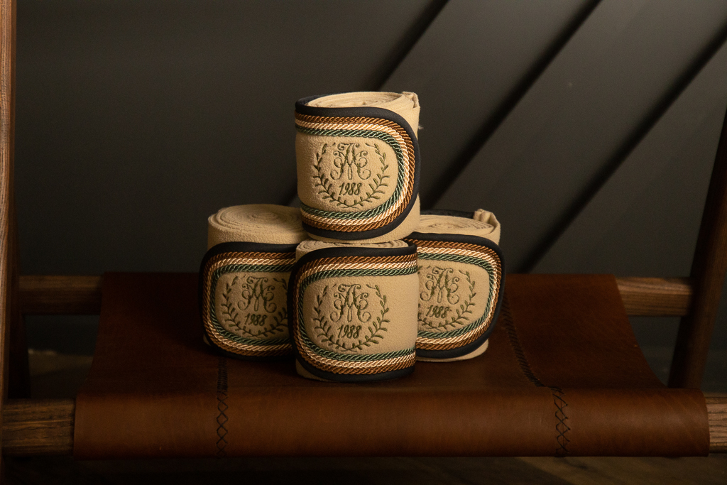 Set of beige bandages with monogrammed embroidery and corded trim
