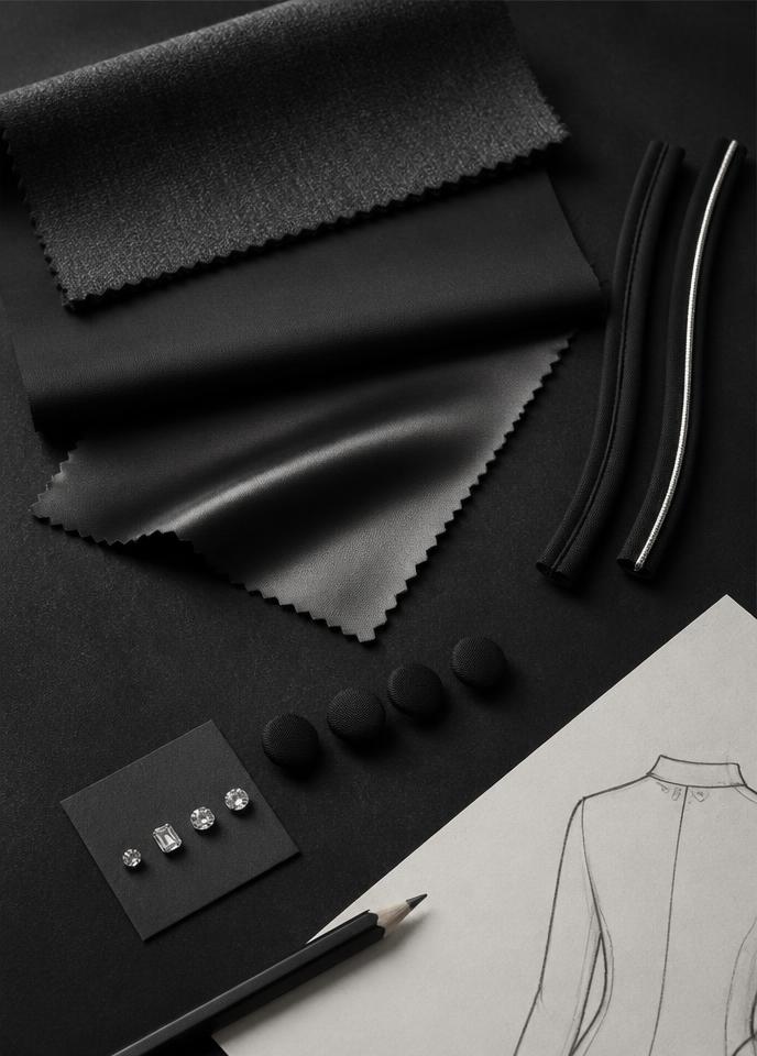 Fabrics, buttons and crystal samples beside a sketch